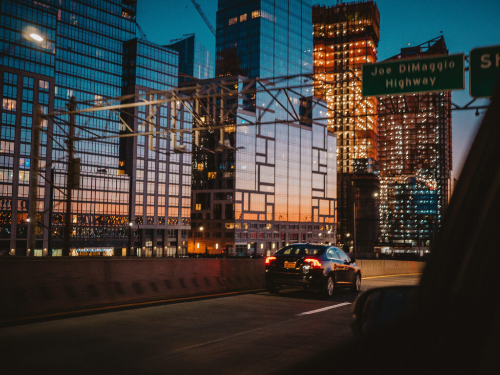 Stunning NYC Night View: Reflective Buildings & Joe DiMaggio Highway Wallpaper