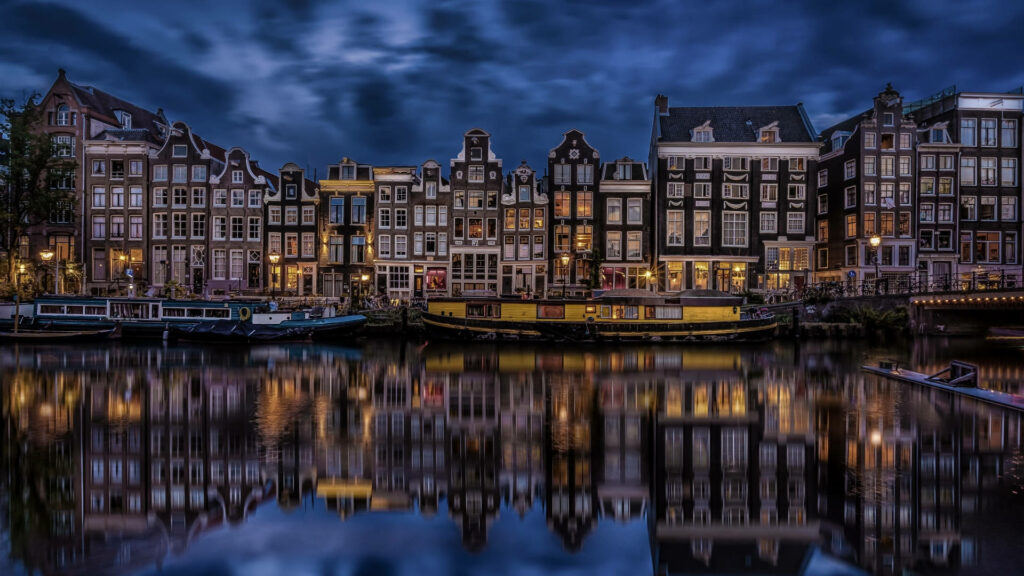 Charming Nighttime Amsterdam: Illuminated Canals Wallpaper Background