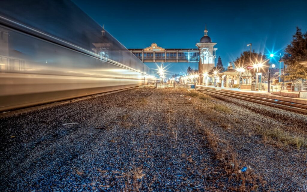Vibrant Nighttime Cityscape Wallpaper: Motion Blur Train Station