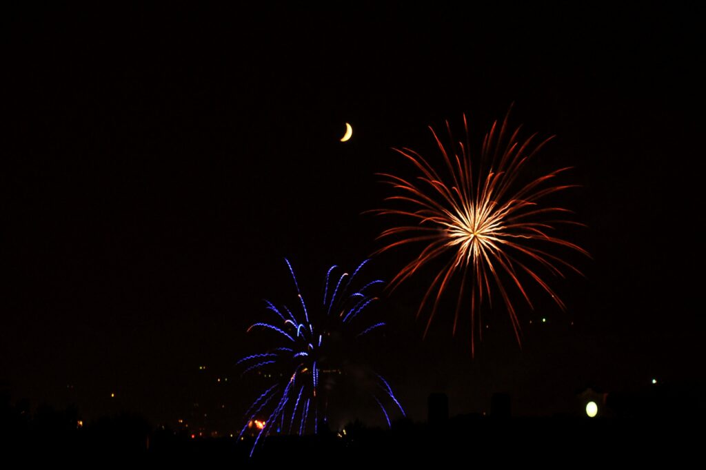 Nighttime Wallpaper: Vibrant Fireworks & Crescent Moon Background