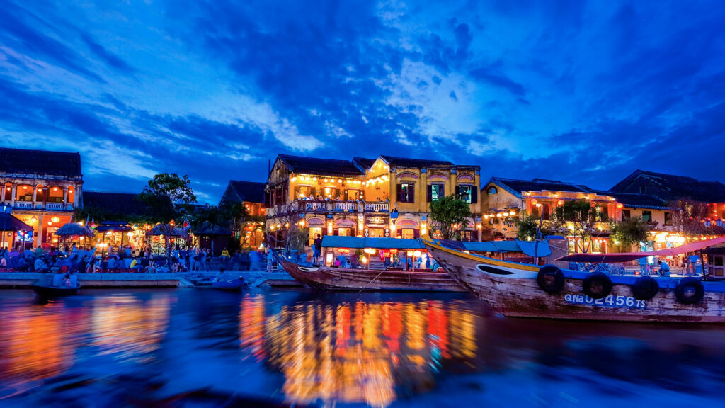 Stunning Riverside Night Scene: Illuminated Boats & Vibrant Reflections Wallpaper