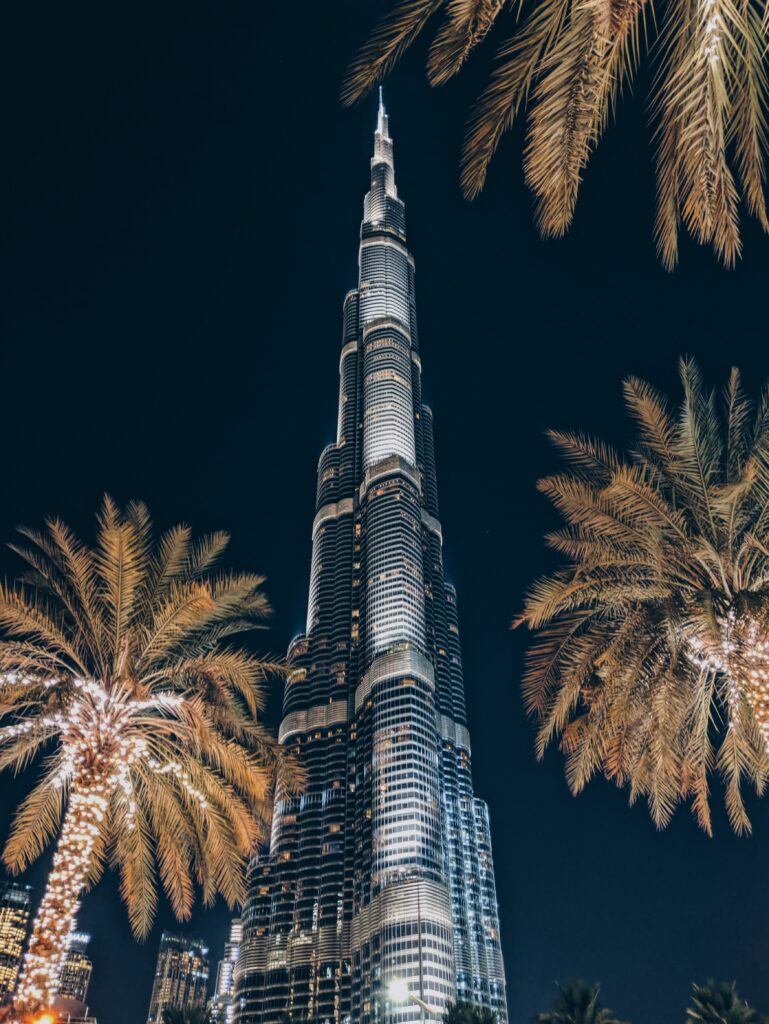 Stunning Nighttime Skyscraper Wallpaper with Palm Trees & Lights