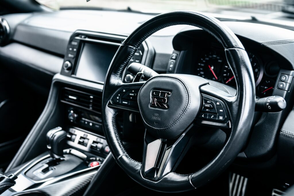 Luxurious Nissan GT-R Interior: Close-Up of Steering Wheel & Speedometer Wallpaper