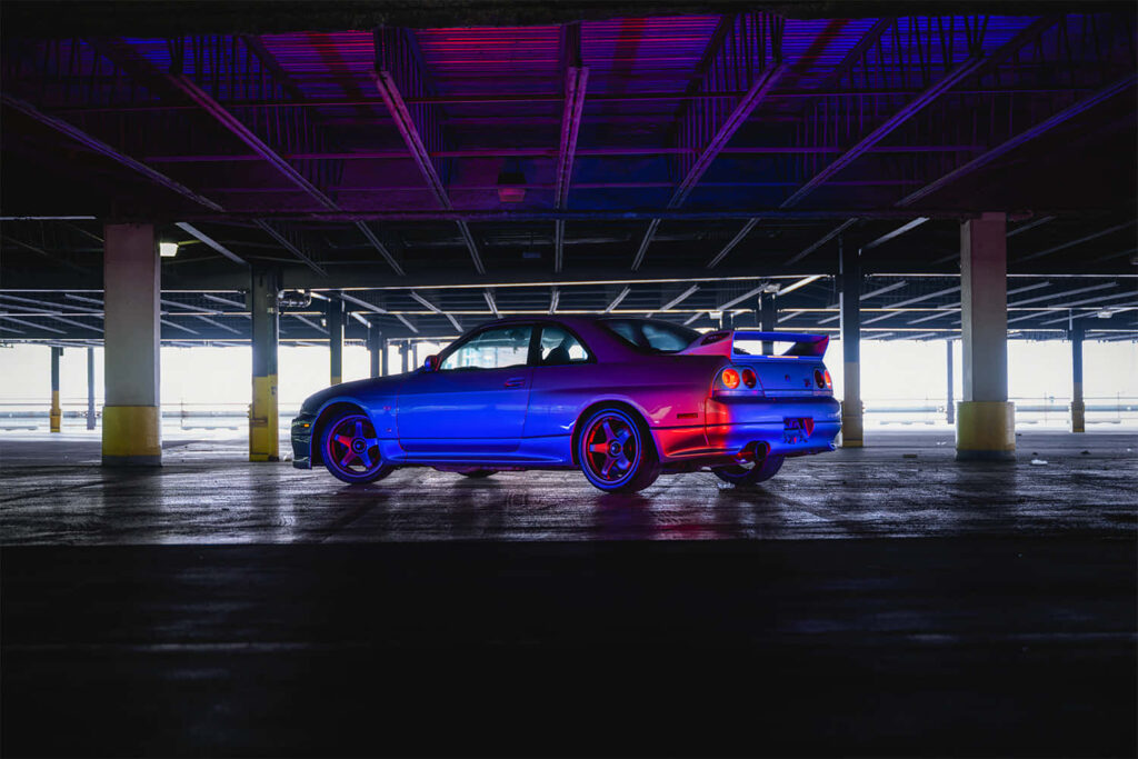 Stunning Nissan R33 GTR Wallpaper: Neon Lights in Parking Garage