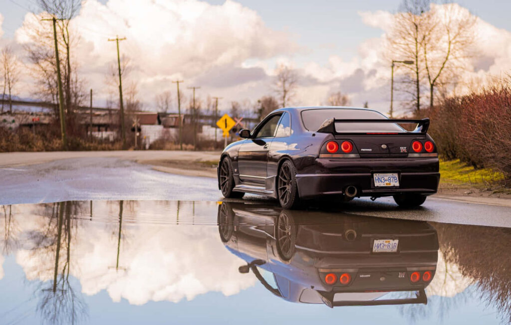 Stunning Nissan R33 GTR Wallpaper: Iconic Car by Reflective Water