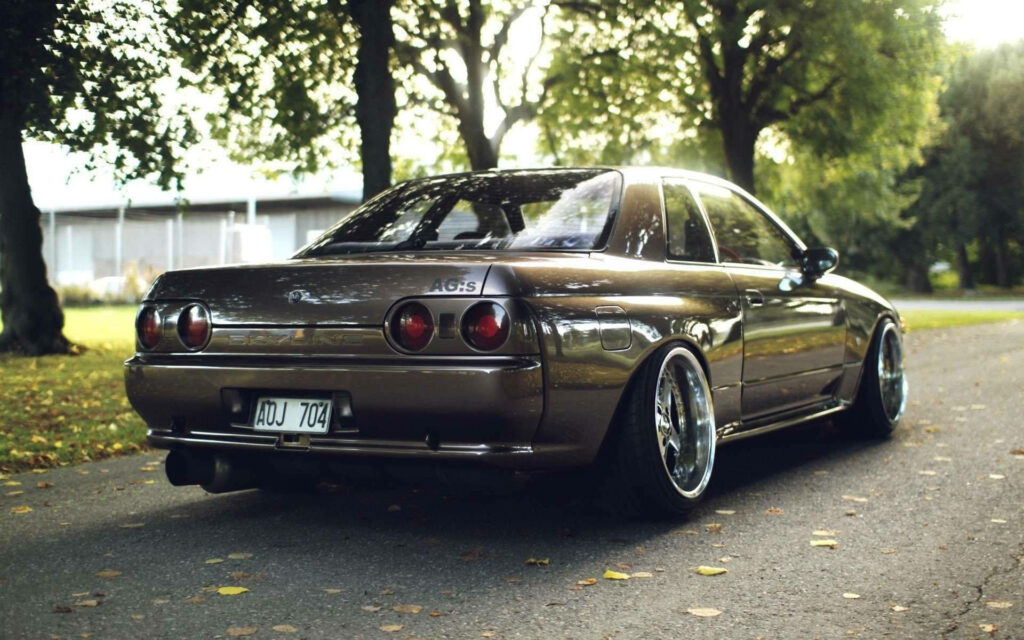 Pristine Nissan Skyline R32 Wallpaper: Serene Road & Lush Greenery