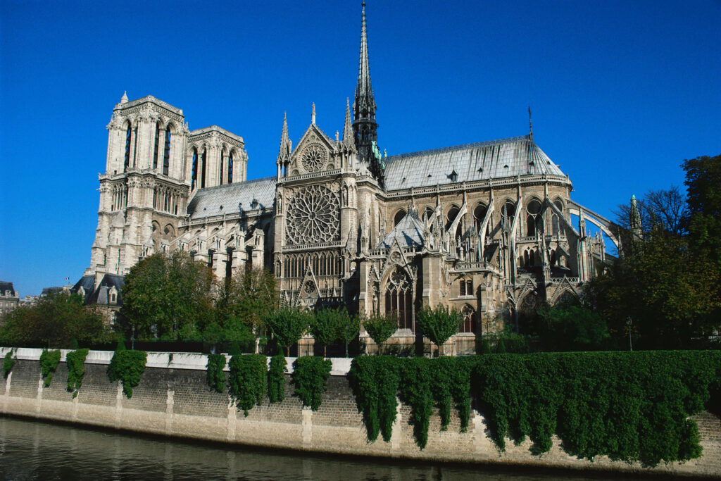 Serene Notre Dame Cathedral Wallpaper with Lush Greenery Accent