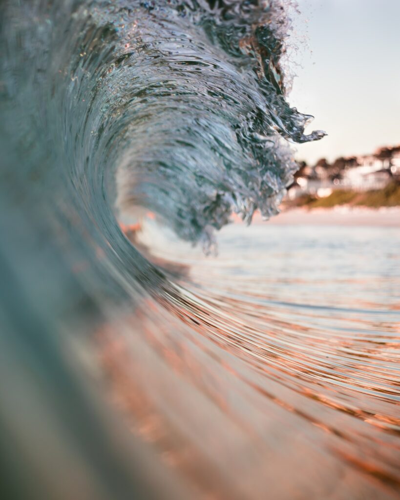 Close-Up Ocean Wave Wallpaper: Sunlit Water Droplets & Motion