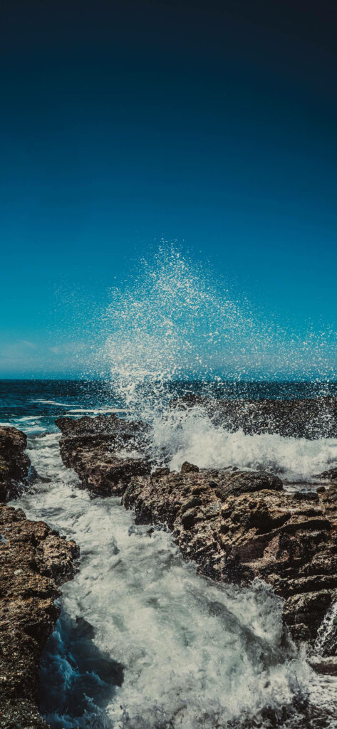 Dynamic Ocean Waves Crash on Rugged Rocks - Stunning Coastal Wallpaper
