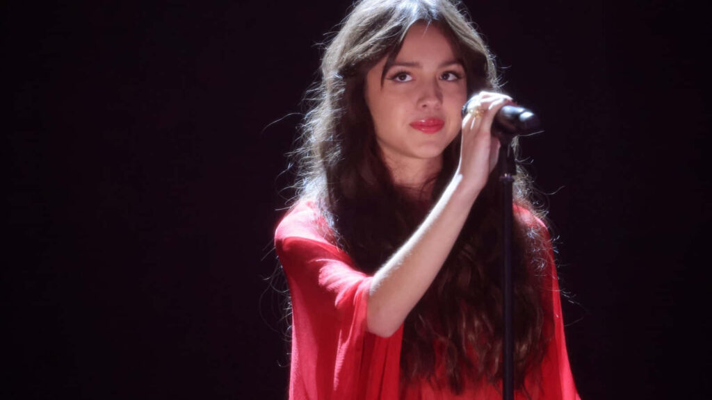 Olivia Rodrigo: Stunning Stage Performance Wallpaper in Vibrant Red