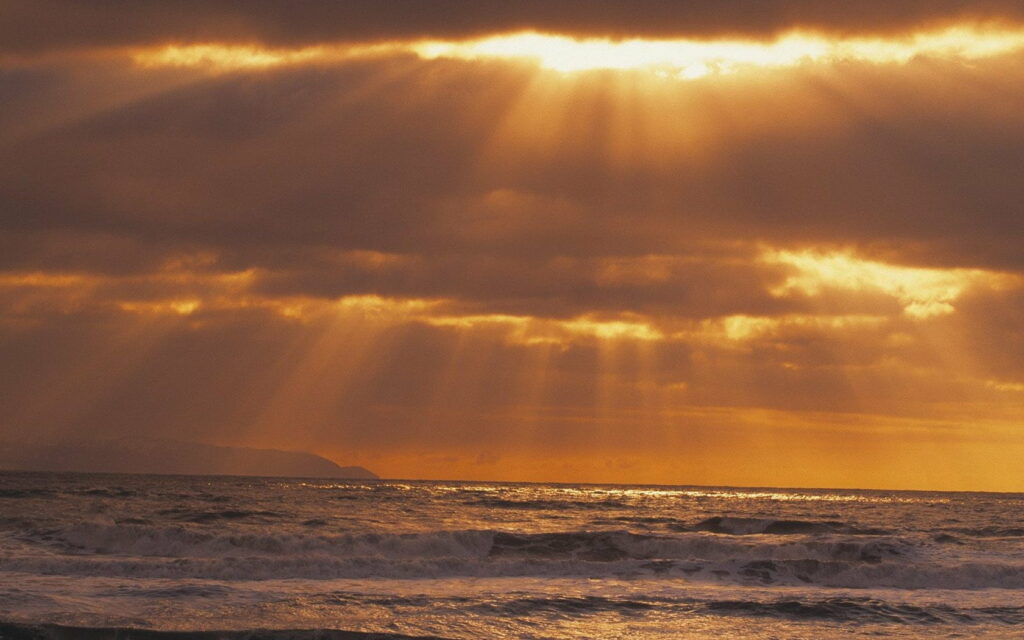 Stunning HD Pacific Ocean Wallpaper: Sunbeams & Dramatic Clouds