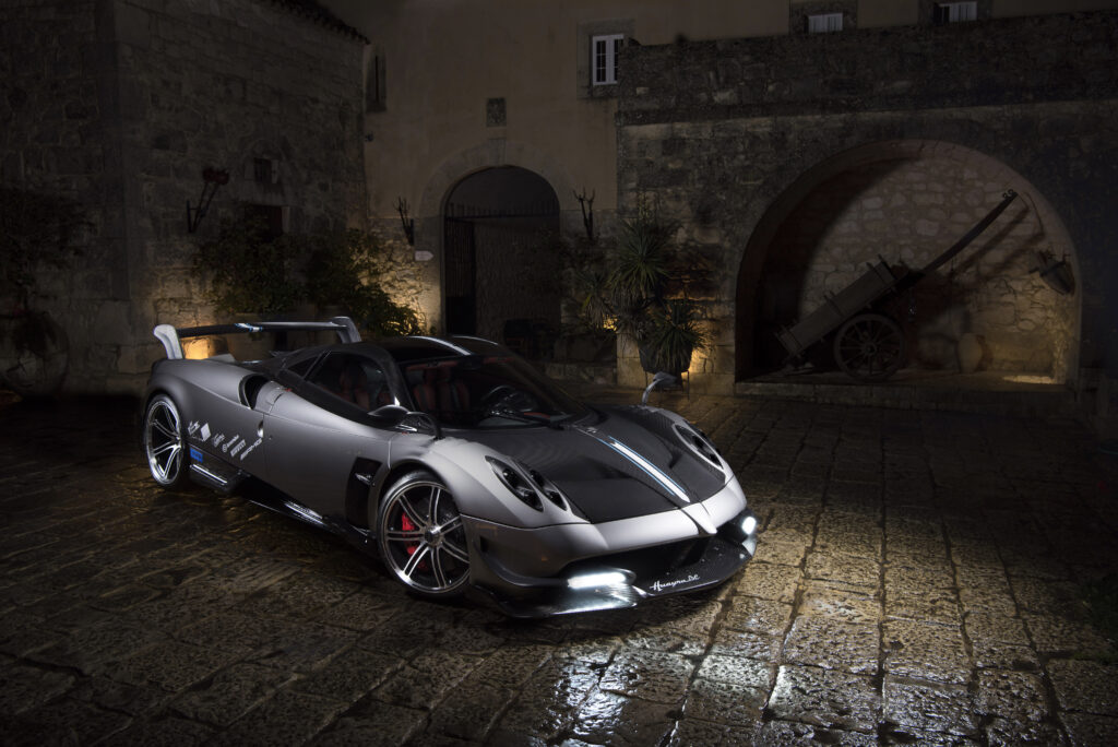 Elegant Pagani Huayra in Rustic Cobblestone Courtyard Wallpaper