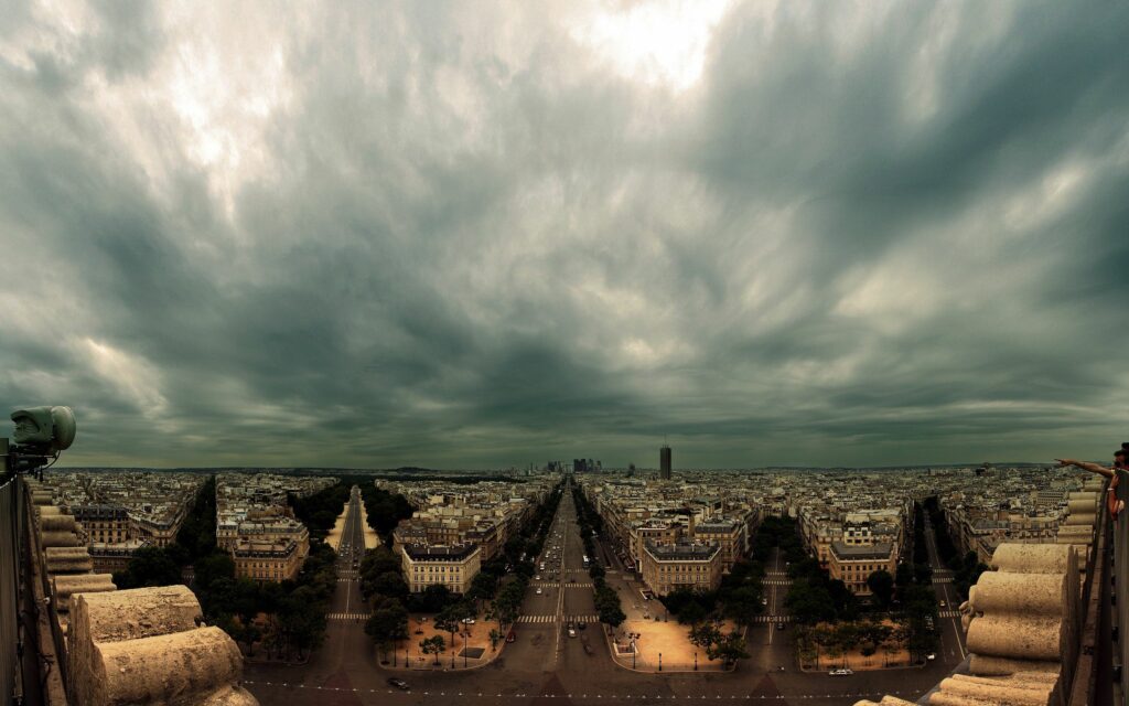 Panoramic Paris Wallpaper: Iconic Cityscape Under Dramatic Sky