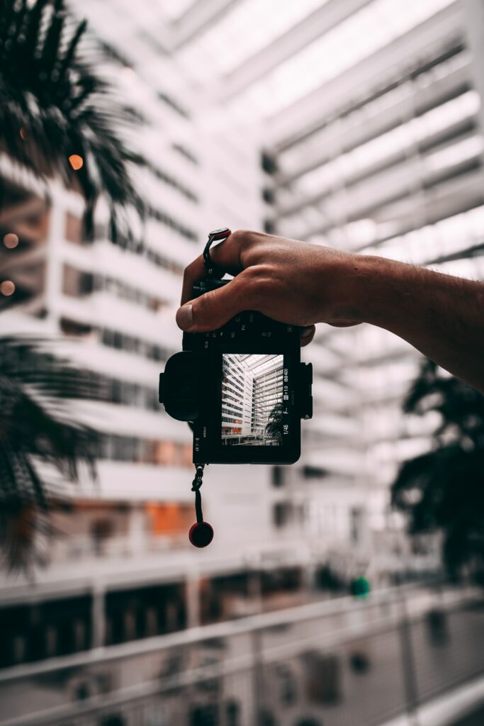 Artistic Wallpaper: Hand Holding Camera with Architectural Framing