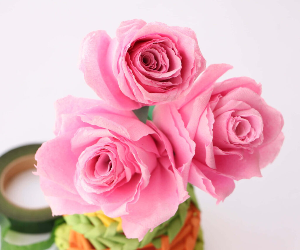 Captivating Pink Paper Roses Against a Simple Background Wallpaper
