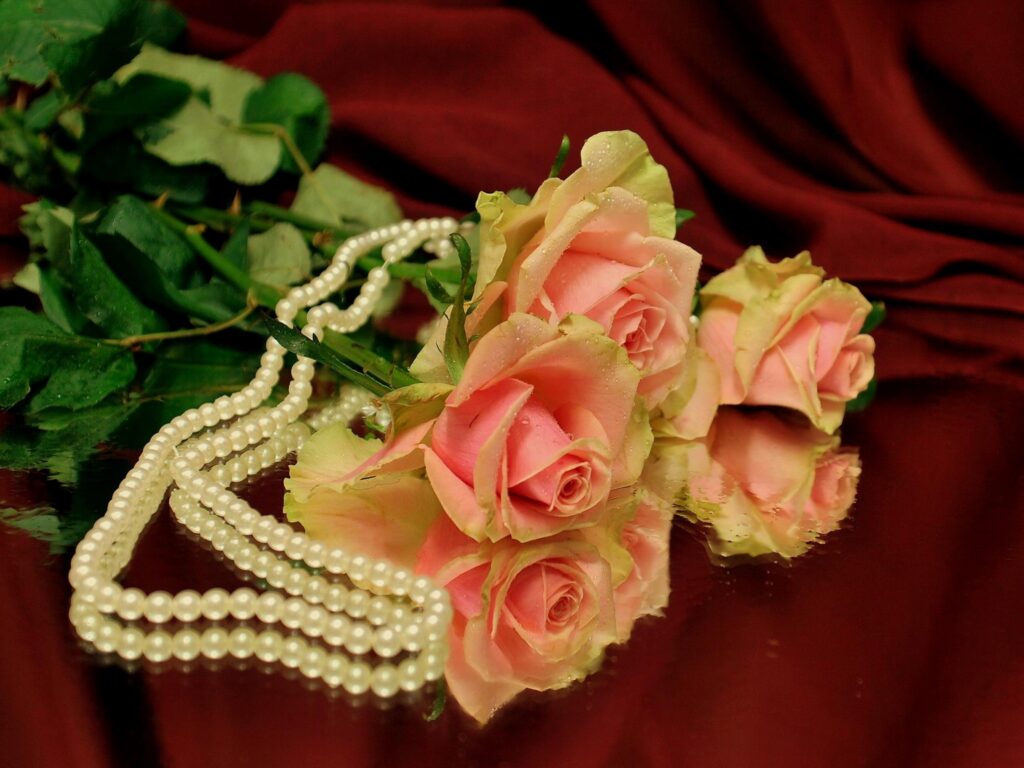 Elegant Pink Roses on Reflective Surface with Pearls - Luxurious Background Wallpaper