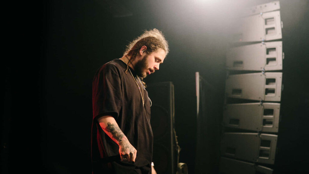 Post Malone Wallpaper: Dramatic Stage Setting with Intense Atmosphere