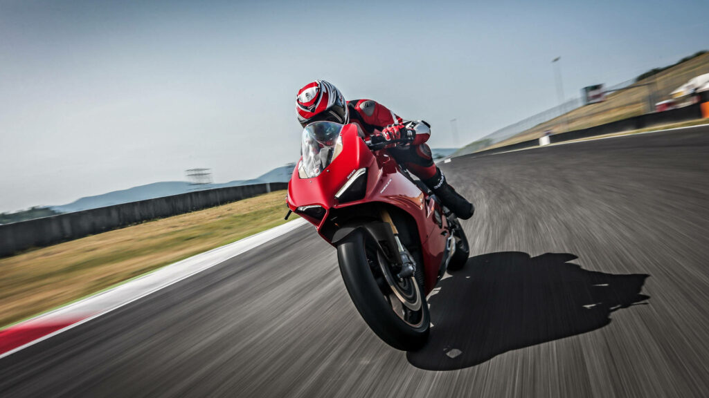 Race Ready Wallpaper: Thrilling Rider on Sleek Red Motorcycle