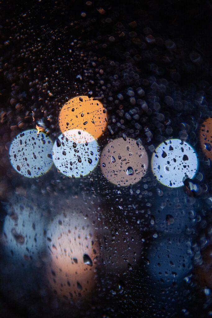 Stunning Raindrops Wallpaper: Bokeh Lights on Glass Surface