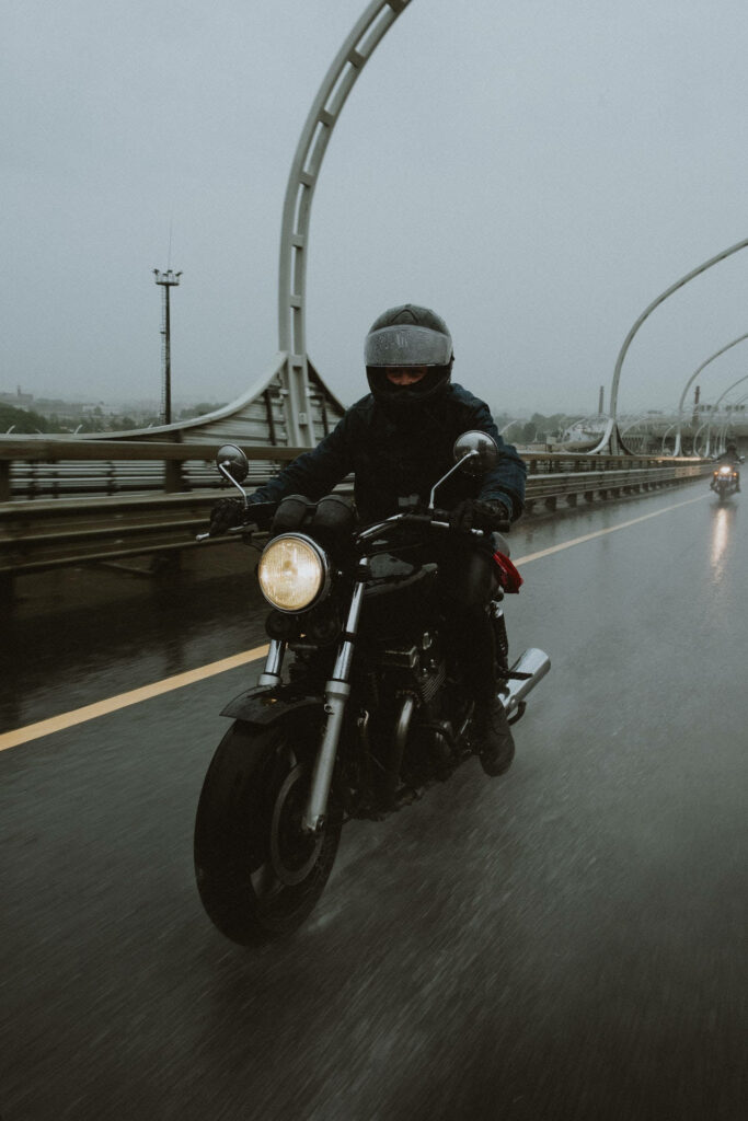 Moody Motorcycle Wallpaper: Biker on Rainy Bridge Adventure