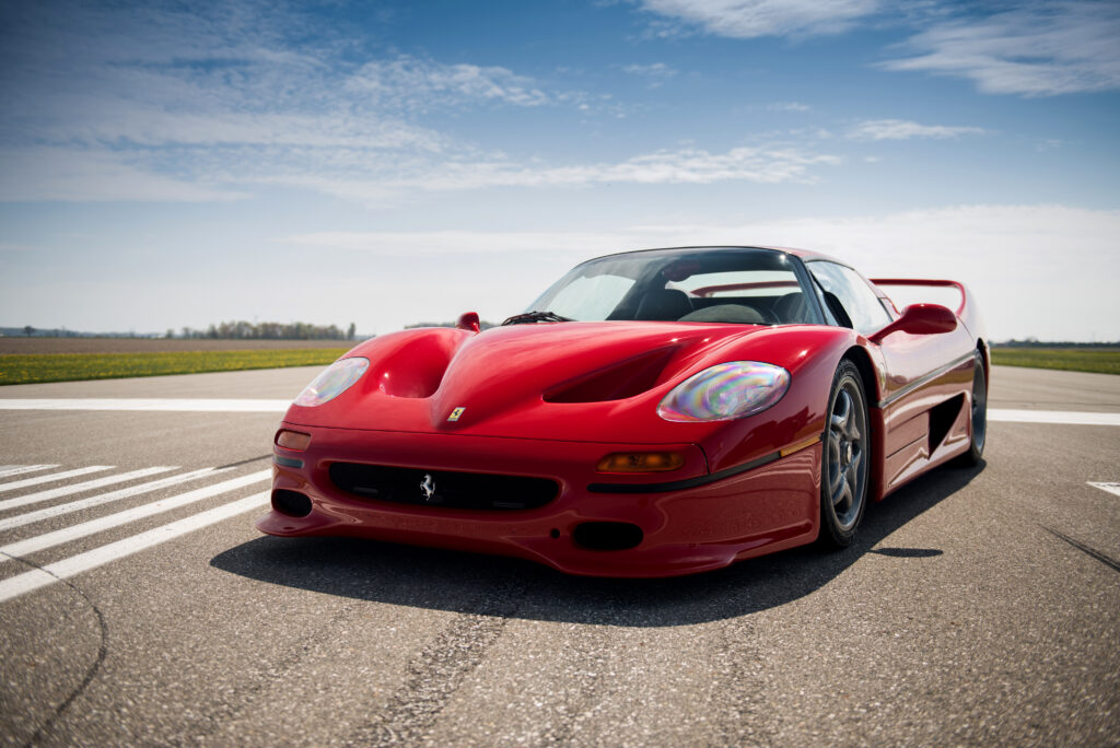 1995 Ferrari F50 Wallpaper: Red Beauty Against Blue Sky Background