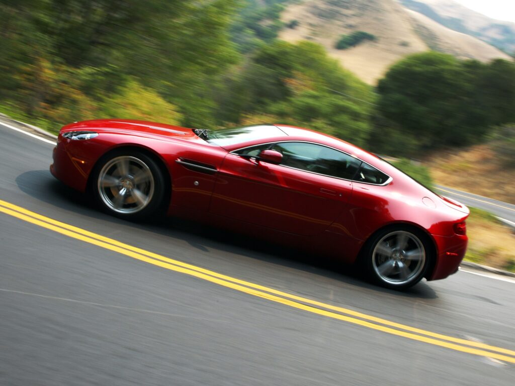 Elegant Red 2008 Aston Martin V8 Vantage on Asphalt Road - Stunning View Wallpaper