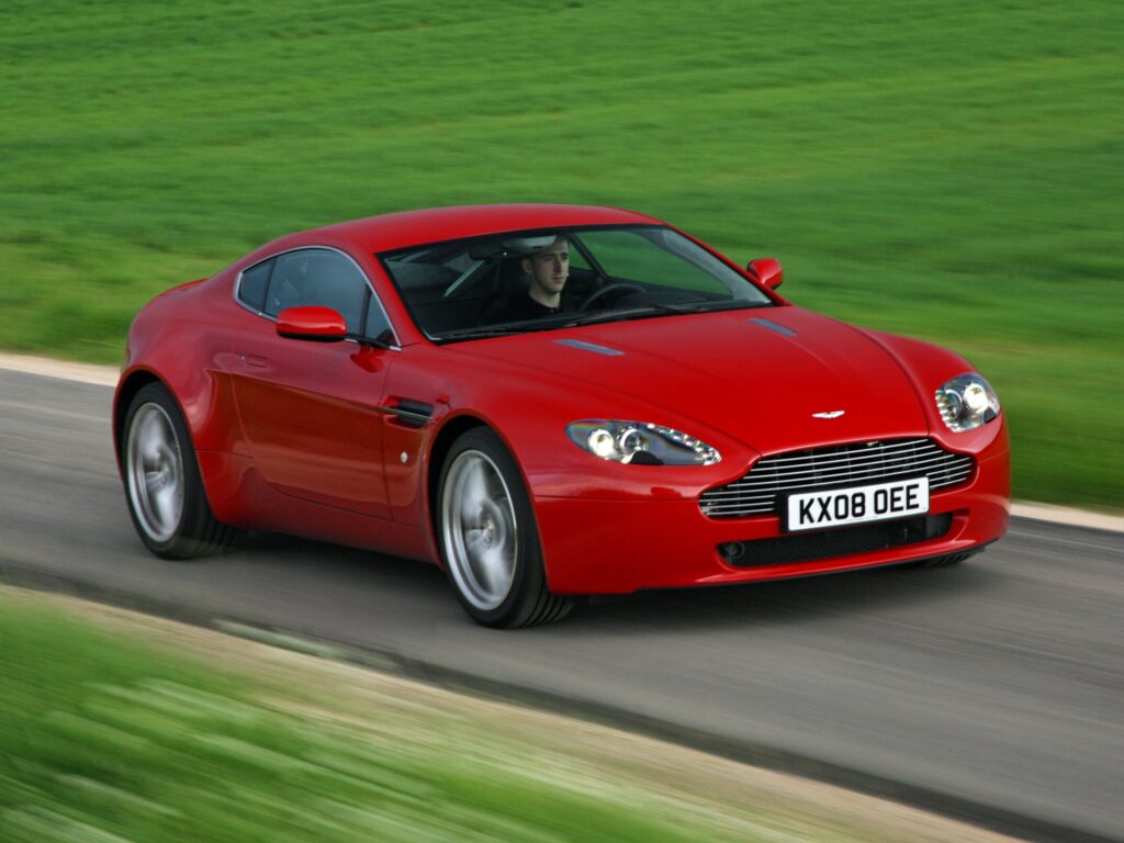 Red 2008 Aston Martin V8 Vantage: Striking Front View with Lush Background Wallpaper