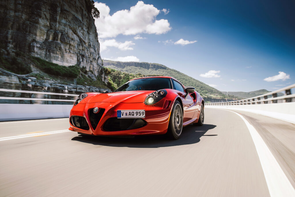 Red Alfa Romeo 4C Wallpaper: Sleek Design Against Scenic Background