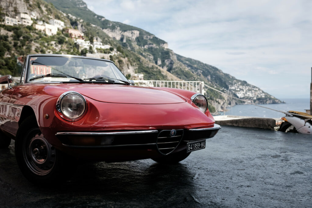 Elegant Red Alfa Romeo Spider: Classic Design Meets Coastal Beauty Wallpaper