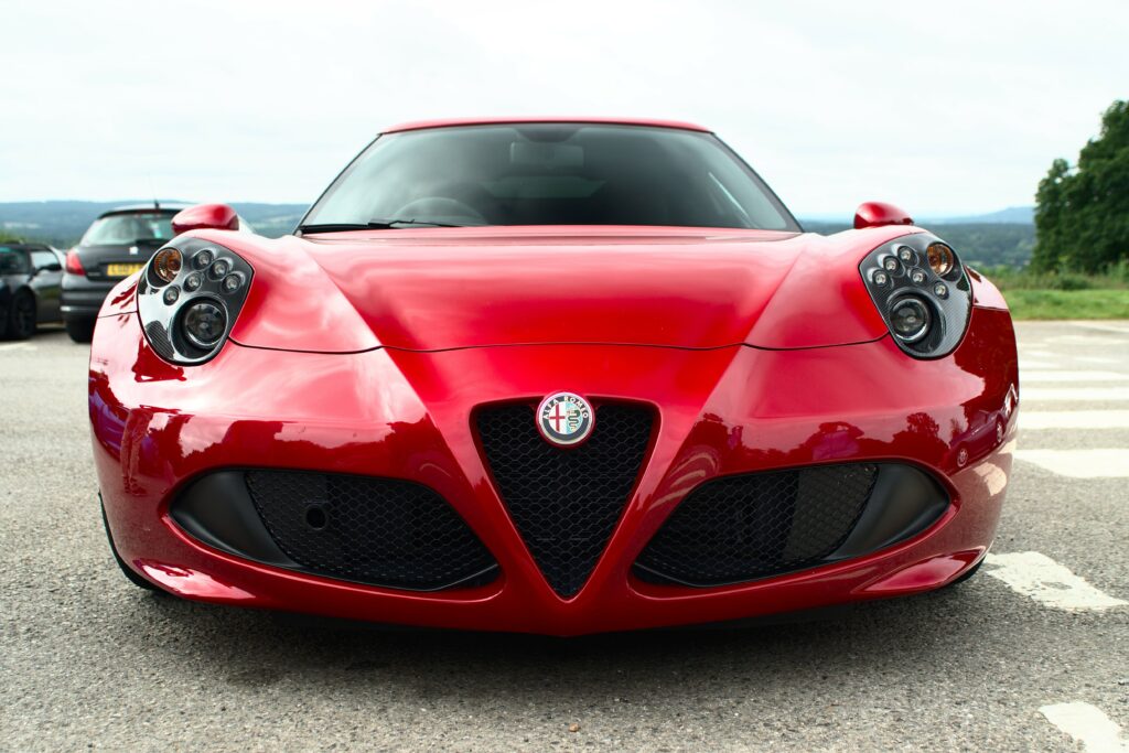 Red Alfa Romeo Wallpaper: Stylish Front View Against Clear Background