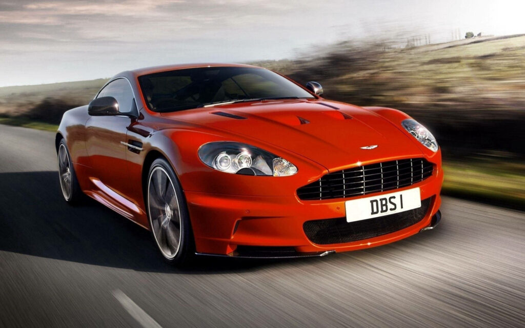 Elegant Red Aston Martin DBS Wallpaper: Power Meets Countryside Serenity