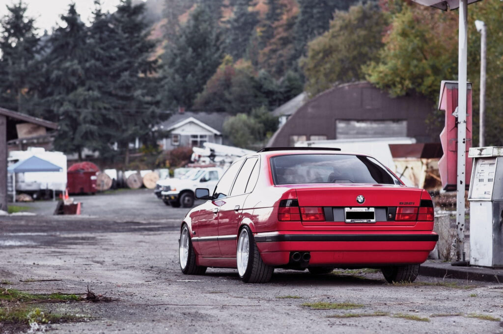 Stunning Red BMW E34 532i Wallpaper Against Rustic Background