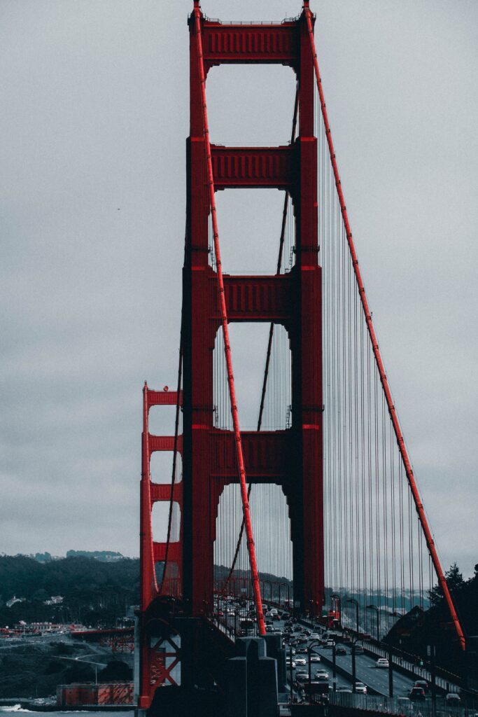 Iconic Red Bridge Wallpaper: Foggy Cityscape with Dynamic Vehicles