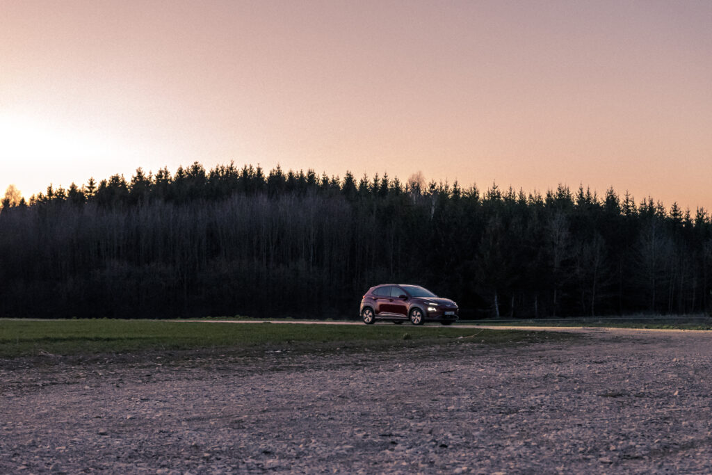Red Car in Forest at Sunset: Tranquil Adventure Wallpaper