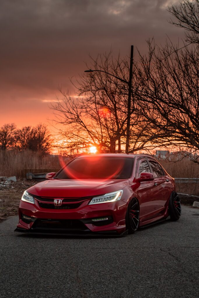 Red Car at Sunset: Front View Wallpaper with Dramatic Background