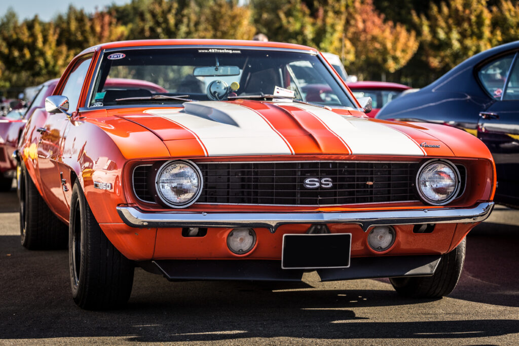 Stunning Red Chevrolet Camaro SS Wallpaper with Bold Stripes & Foliage