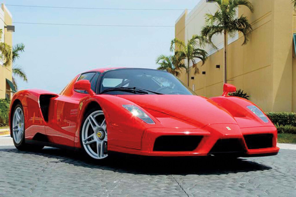 Speed and Luxury Unleashed: The Enthralling Red Ferrari Enzo Dashes through Scenic Beauty Wallpaper