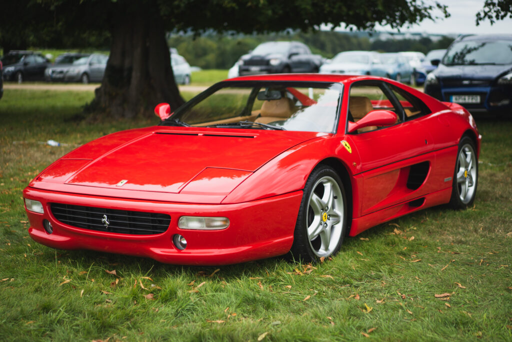 Stunning Red Ferrari F355 Wallpaper - Elegant Sports Car in Grass