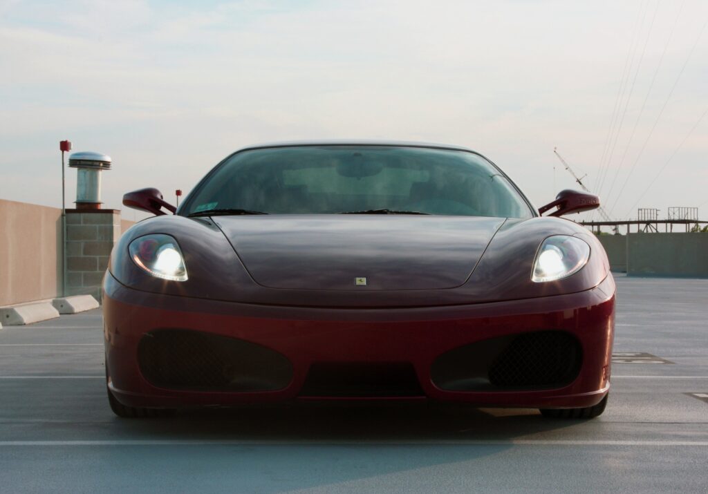 Red Ferrari F430 Wallpaper: Sleek Design Against Serene Sky Background