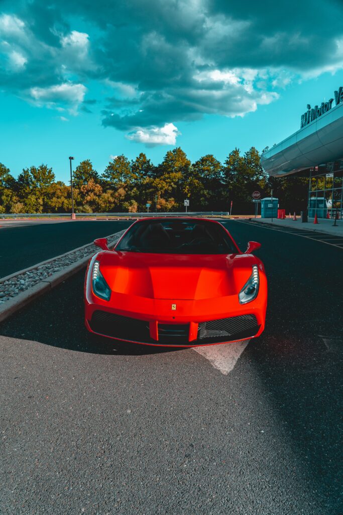 Stunning Red Ferrari Under Dramatic Sky - Urban Wallpaper