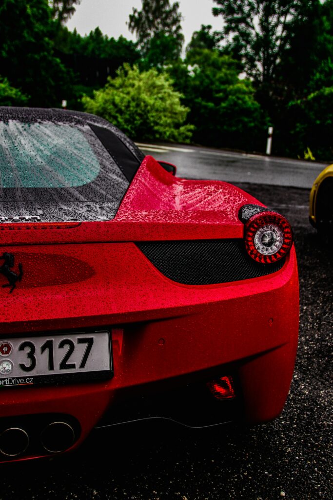 Stunning Red Ferrari Sports Car Wallpaper with Lush Background