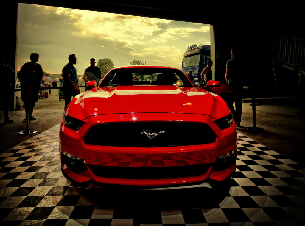 Vibrant Red Ford Mustang Wallpaper with Dramatic Lighting & Checkered Floor