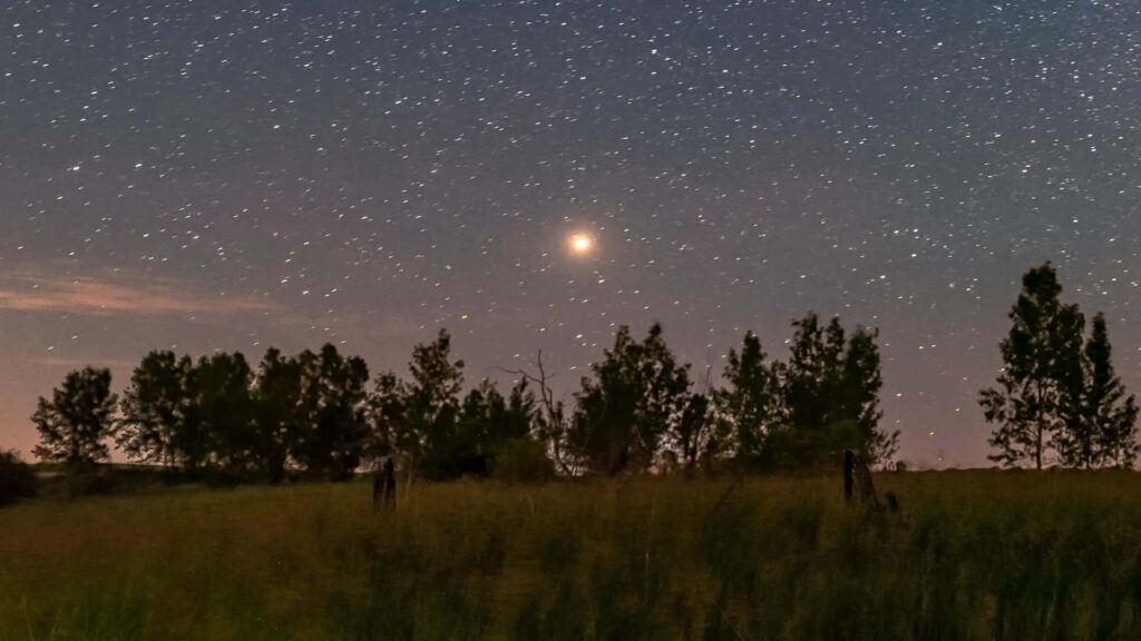Stunning Red-Hued Celestial Body Wallpaper Against Starry Night Sky