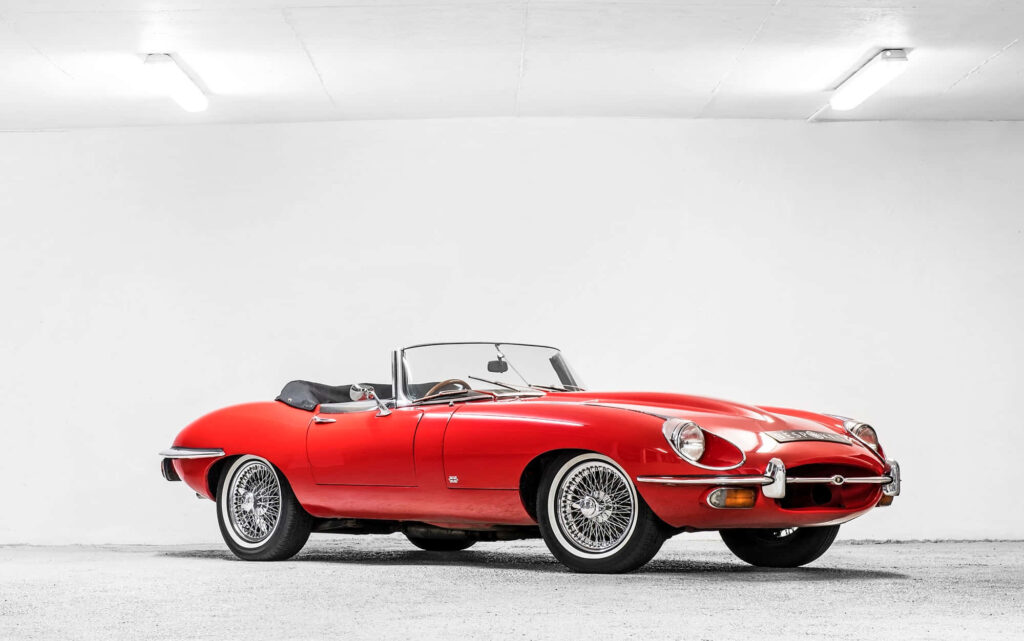 Elegant Red Jaguar E-Type Wallpaper on Minimalist White Background