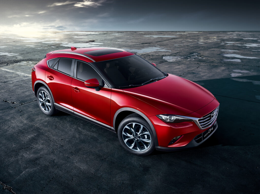 Stunning Red Mazda CX-4 Side View Wallpaper Against Rugged Background