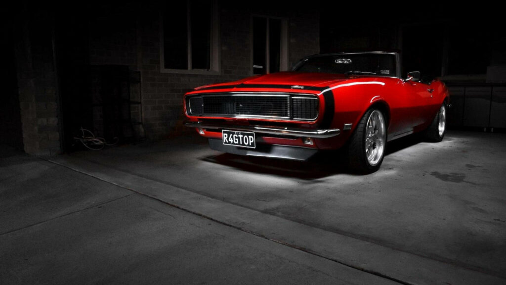 Stunning Red Muscle Car Wallpaper: Bold Design in Dark Garage