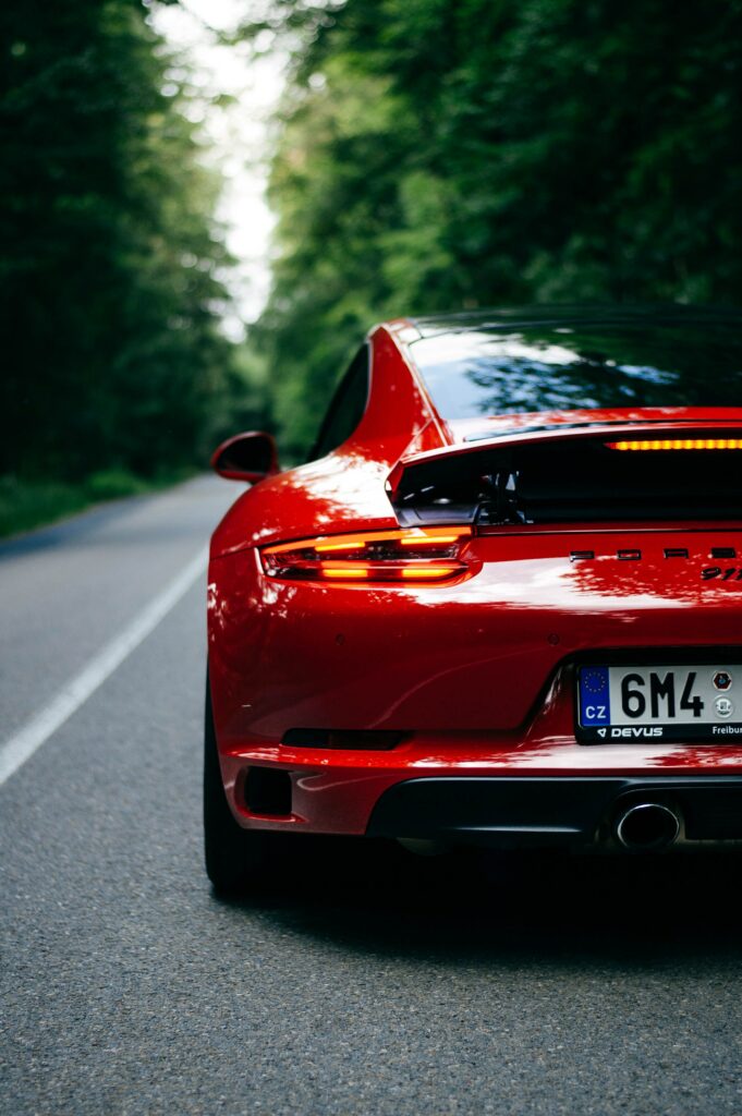 Sleek Red Porsche 911 Wallpaper - Scenic Road View with Lush Greenery