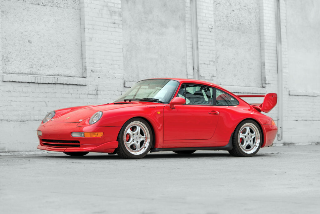 Red Porsche Carrera Wallpaper: Sleek Design Against Urban Backdrop