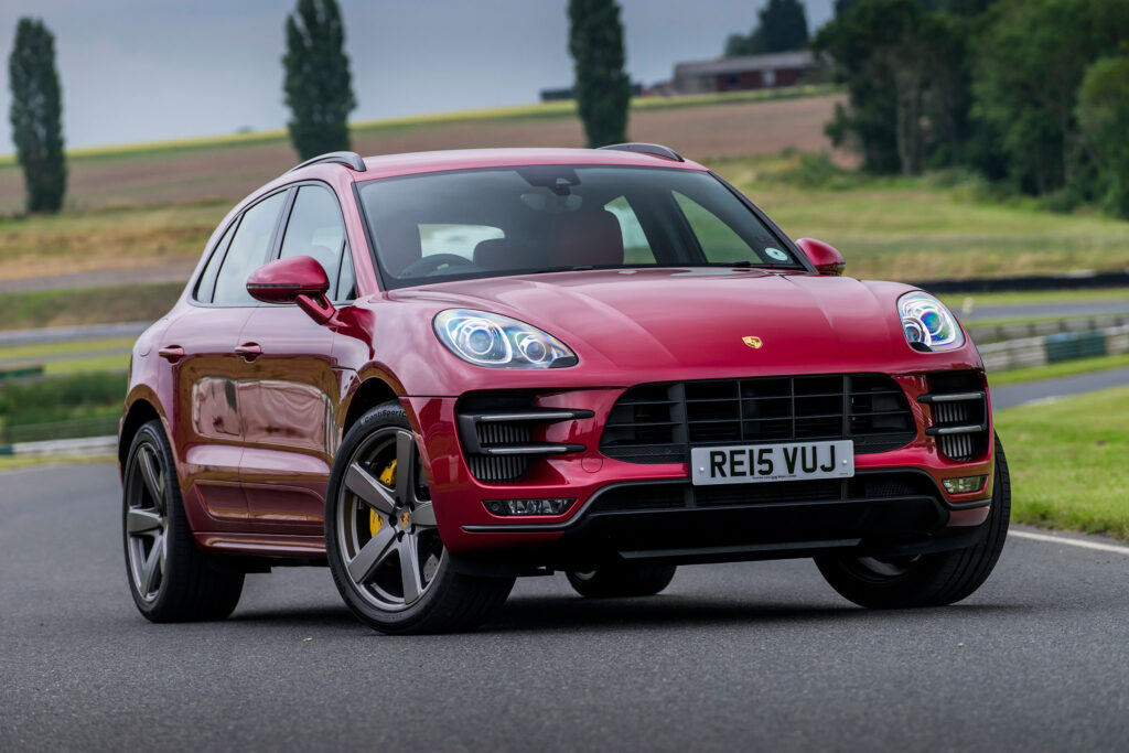 Red Porsche Macan Turbo: Dynamic Design Wallpaper with Scenic Background