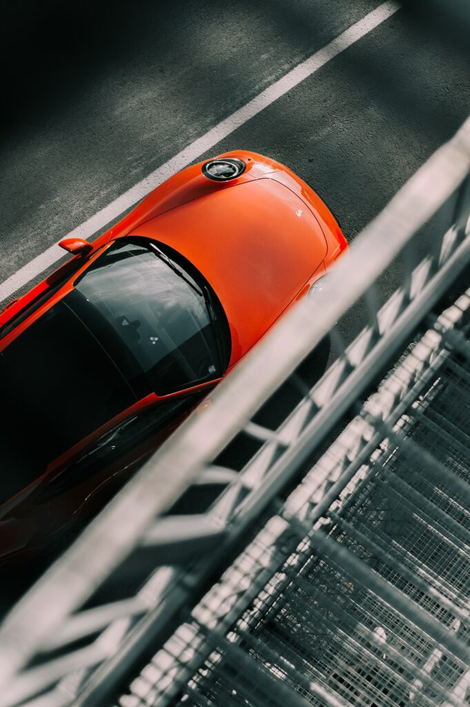 Stunning Top View of a Red Porsche on Textured Asphalt Wallpaper